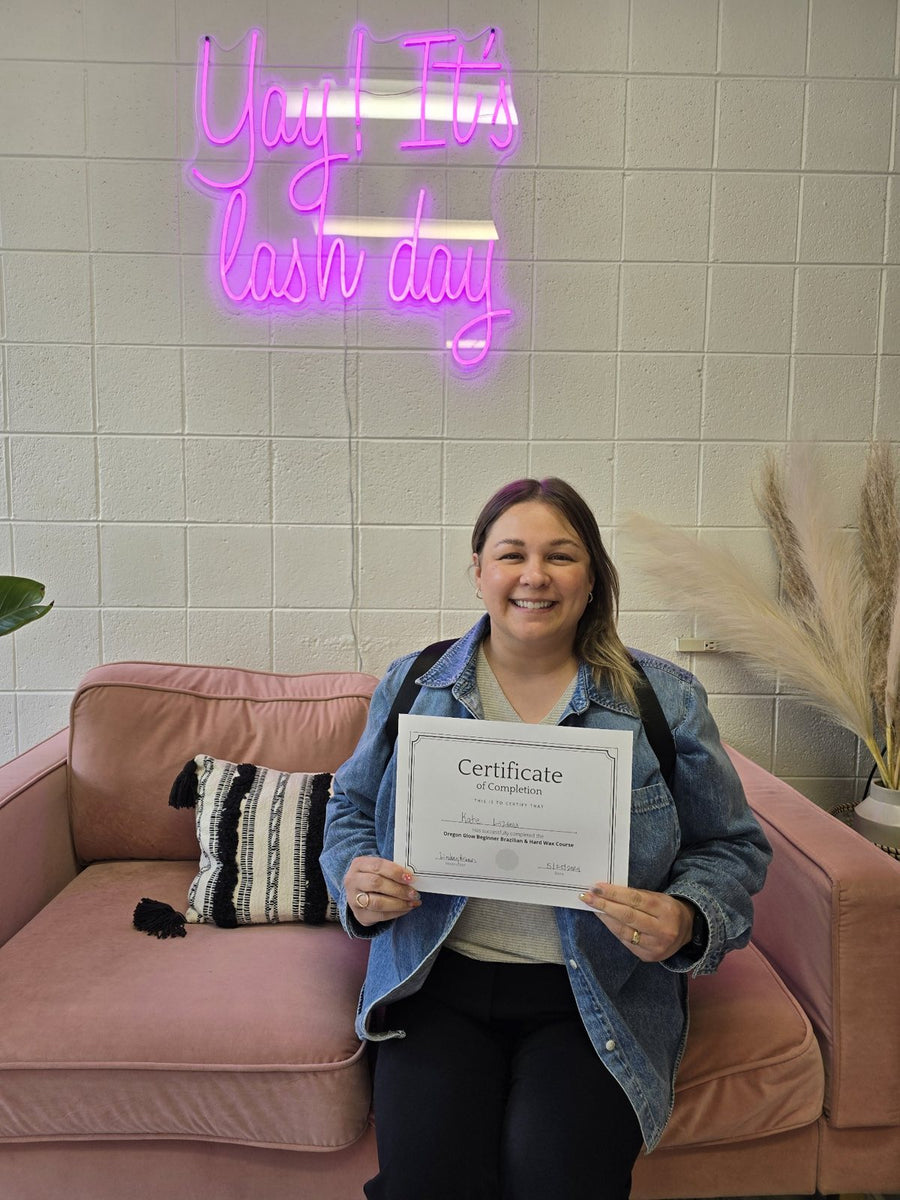 Smiling Oregon Glow Brazilian wax training graduate with her certificate