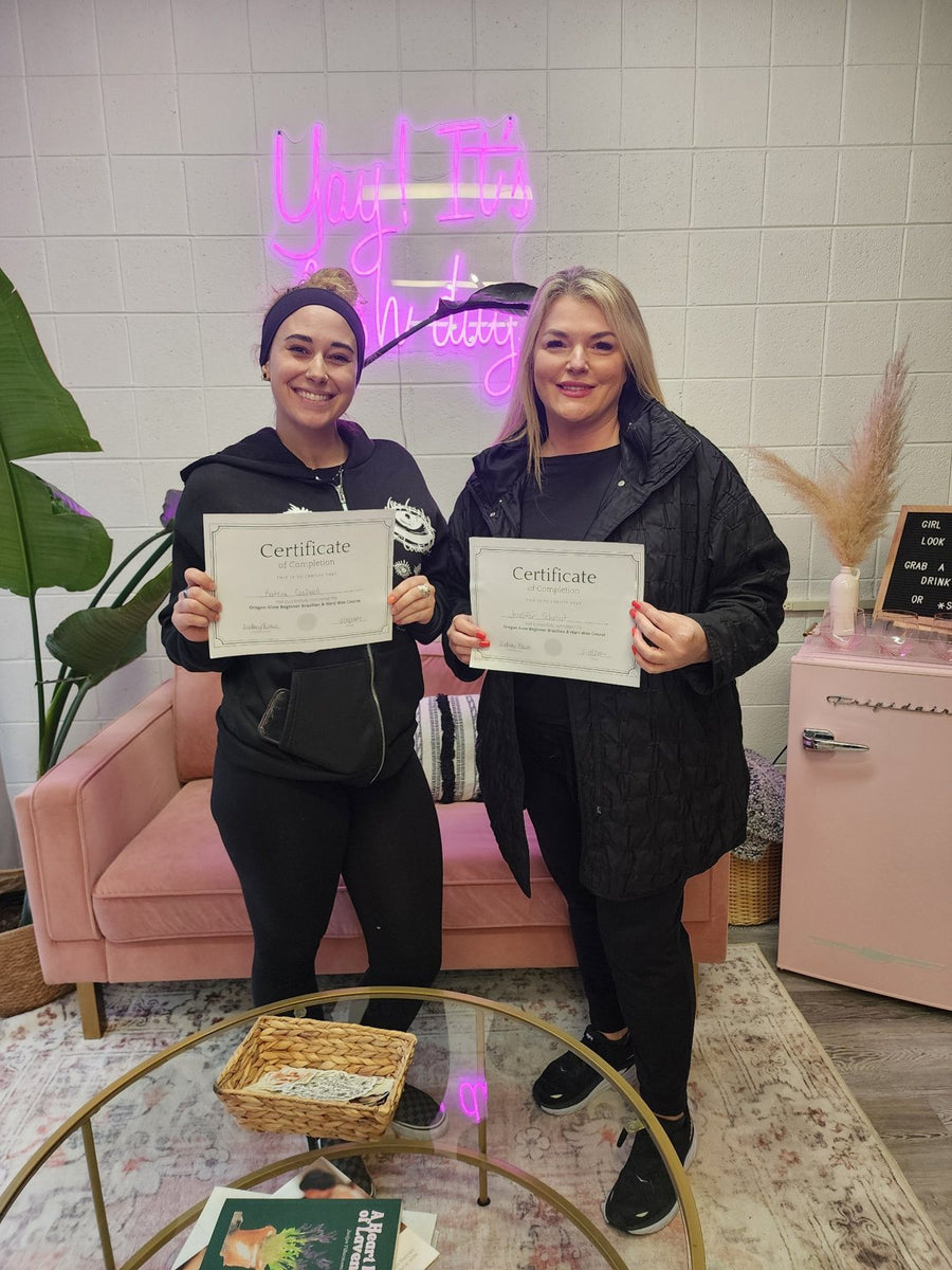 Two Oregon Glow Brazilian wax training graduates holding their certificates in Junction City, OR