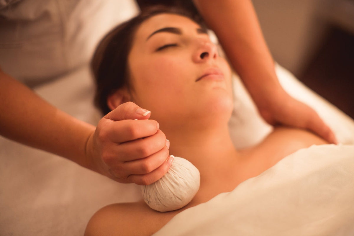 Client relaxing during a warm herbal compress facial at Oregon Glow in Junction City